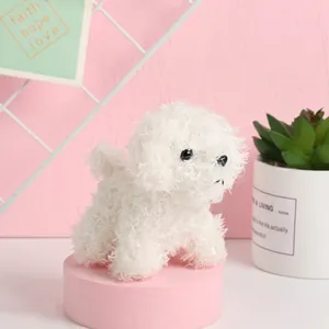 Cute white curly plush dog toy puppy doll displayed on a pink pedestal stand