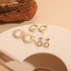 Detailed macro view of 14K gold plated cubic zirconia earrings in star and square shapes