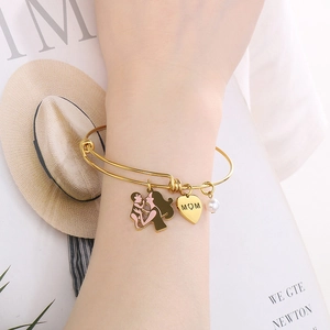 Adjustable gold MOM bracelet with pearl and heart charms on model lifestyle background