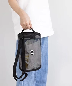 Mesh travel toiletry bag with eye pattern featuring a top handle and shoulder strap