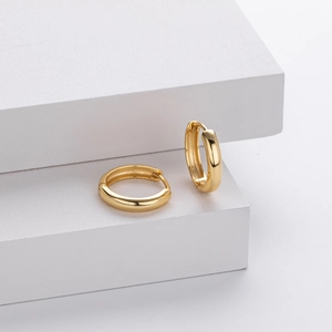Close-up of polished S925 sterling silver hoop earrings with visible 925 hallmark