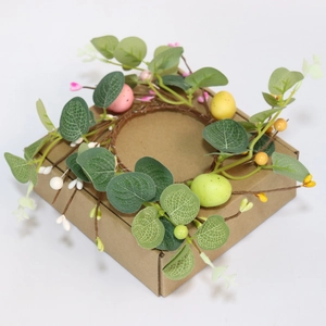 Easter candle ring wreath with eucalyptus leaves, colorful eggs, and small berries