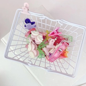 Close-up of a white mini metal basket filled with colorful heart-shaped plastic clips