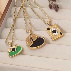 Three gold 18K plated stainless steel necklaces with heart, eye, and bag pendants