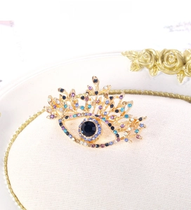 Macro shot of evil eye brooch featuring colorful rhinestones and gold alloy setting