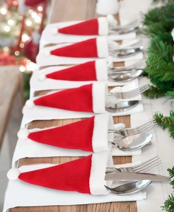 Set of mini red and white Santa hat cutlery holders for Christmas table decoration