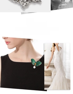 Detailed view of alloy butterfly brooch with green enamel, crystals and pearl pendant
