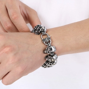 Close-up of hip hop silver stainless steel skull bracelet worn on male wrist
