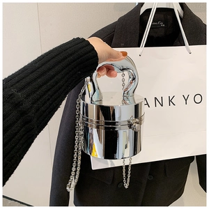 Detail view of mirror silver cylindrical crossbody bag with metal chain and handle