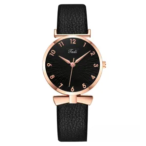 Close-up of black sunburst dial with rose gold numerals and leather strap detail