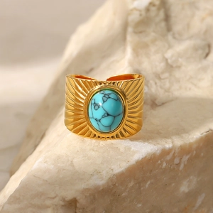 French retro 18K gold wide ribbed ring with oval turquoise stone on beige rock