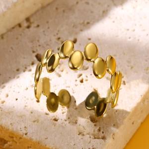 Close-up of a gold-plated irregular geometric stainless steel open ring on a stone base
