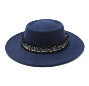 Primer plano del sombrero de lana azul marino con banda decorativa de borlas de plata