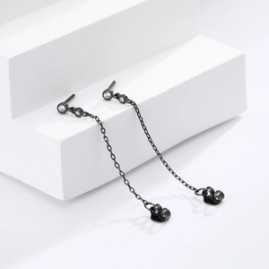 Détail des boucles d'oreilles à chaîne pendante noire avec zircons blancs brillants
