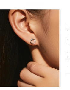 Close-up of minimalist S925 sterling silver wavy stud earring worn on model ear