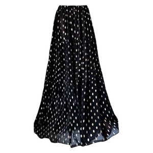Close-up of black mesh maxi skirt with elegant gold polka dot pattern and tiered hem