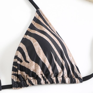 Detailed close-up of halter bikini top featuring black and sand zebra animal print pattern