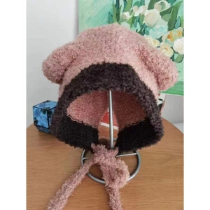 Dettaglio del berretto con orecchie da orso rosa e marrone con lacci lunghi