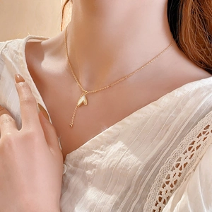 Détail d'un collier en perles papillon plaqué or avec pendentif délicat en zircon