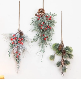 Hanging Christmas garland with pine needles, red berries, and natural pinecones on a wall