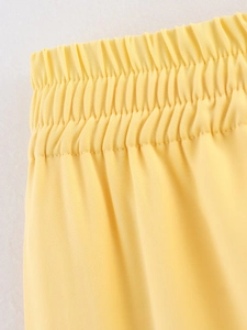 Detail of high-density twill fabric and elastic waistband on yellow safari trousers