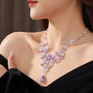 Detail of silver vintage necklace with purple zircon flower patterns and water drop pendant