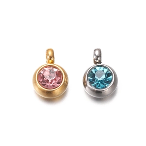 Detail view of round stainless steel pendants with pink and blue faceted zircons
