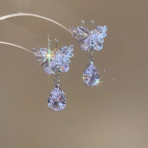 Close-up of butterfly earrings with water-drop crystals and shimmering zircon details