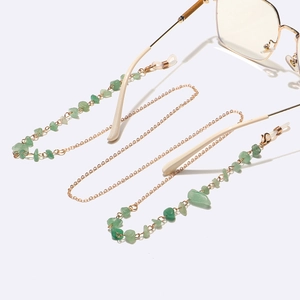 Detail of gold link chain with green aventurine natural stones for glasses or masks