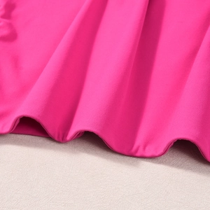 Détail du tissu magenta montrant le drapé fluide et la texture fine à armure toile