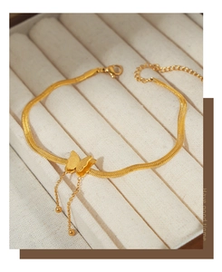 Detail view of gold butterfly double-layer anklet with frosted pendant and tassel chains