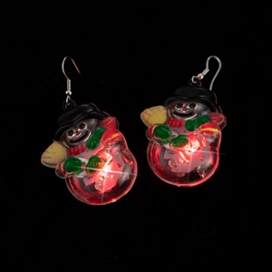 Detail of glowing snowman Christmas earrings with red LED lights and metal hooks