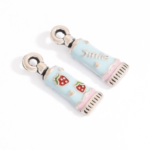 Detail of blue enamel toothpaste pendants with strawberry pattern and Smile lettering