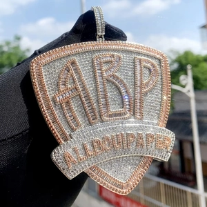 Close-up of hip hop shield pendant with ABP letters and micro-pave zircons in silver tone