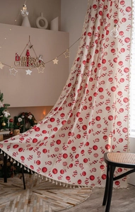 Detail of Christmas candy pattern curtains with decorative tassels on beige cotton linen fabric