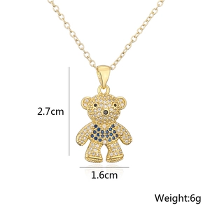 Golden teddy bear pendant necklace with blue and clear zircon stones on a white background