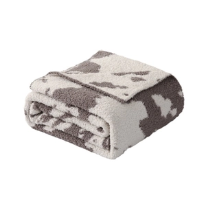 Thick faux fur cow print blanket neatly folded for home sofa or bedroom decor