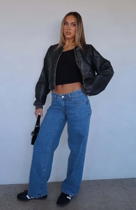 Close-up of a stylish short black PU leather bomber jacket with mid-waist straight-leg jeans