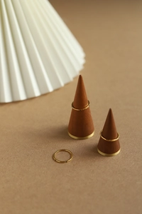 Detailed view of three minimalist 18K gold plated thin rings stacked on a wooden cone