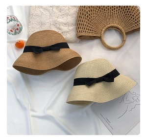 Detailed weave texture of cloche straw hats with black grosgrain bows and matching bags