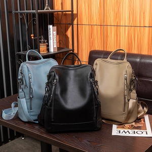 Three minimalist soft PU leather backpacks in blue, black, and khaki with lychee texture