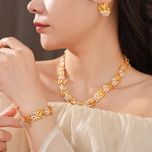 Macro detail of luxury vintage gold leaf jewelry set with pearls and diamonds on a model