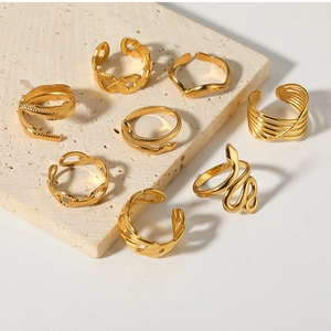 Detail view of 8-piece gold ring set including snake and chain patterns on stone pedestal