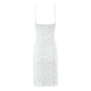 Détail d'une robe blanche à fines bretelles avec motifs de petites fleurs roses et mauves
