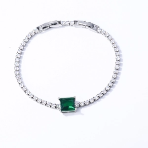 Detail of emerald cut green gemstone and round cubic zirconia in a silver tennis bracelet