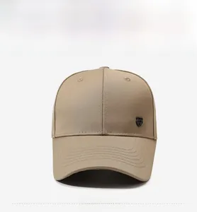 Detail of khaki cotton baseball cap with metal shield badge and reinforced stitched brim