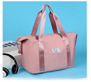 Pink nylon travel bag detail showing wide handles and bottom dry-wet separation layer