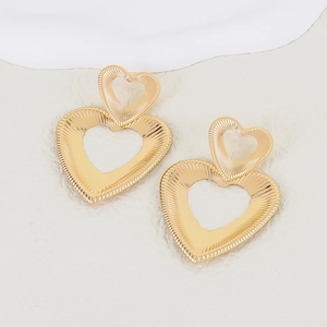 Polished gold layered heart drop earrings with radial texture on stone background