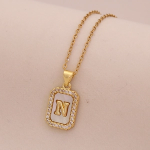 Détail du pendentif rectangulaire en or 18K avec nacre et lettre N gravée