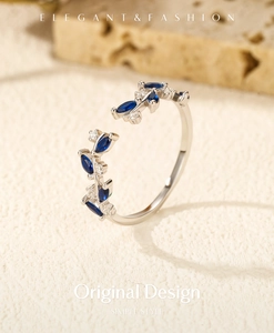 Detail of adjustable silver vine ring featuring blue marquise and white round stones
